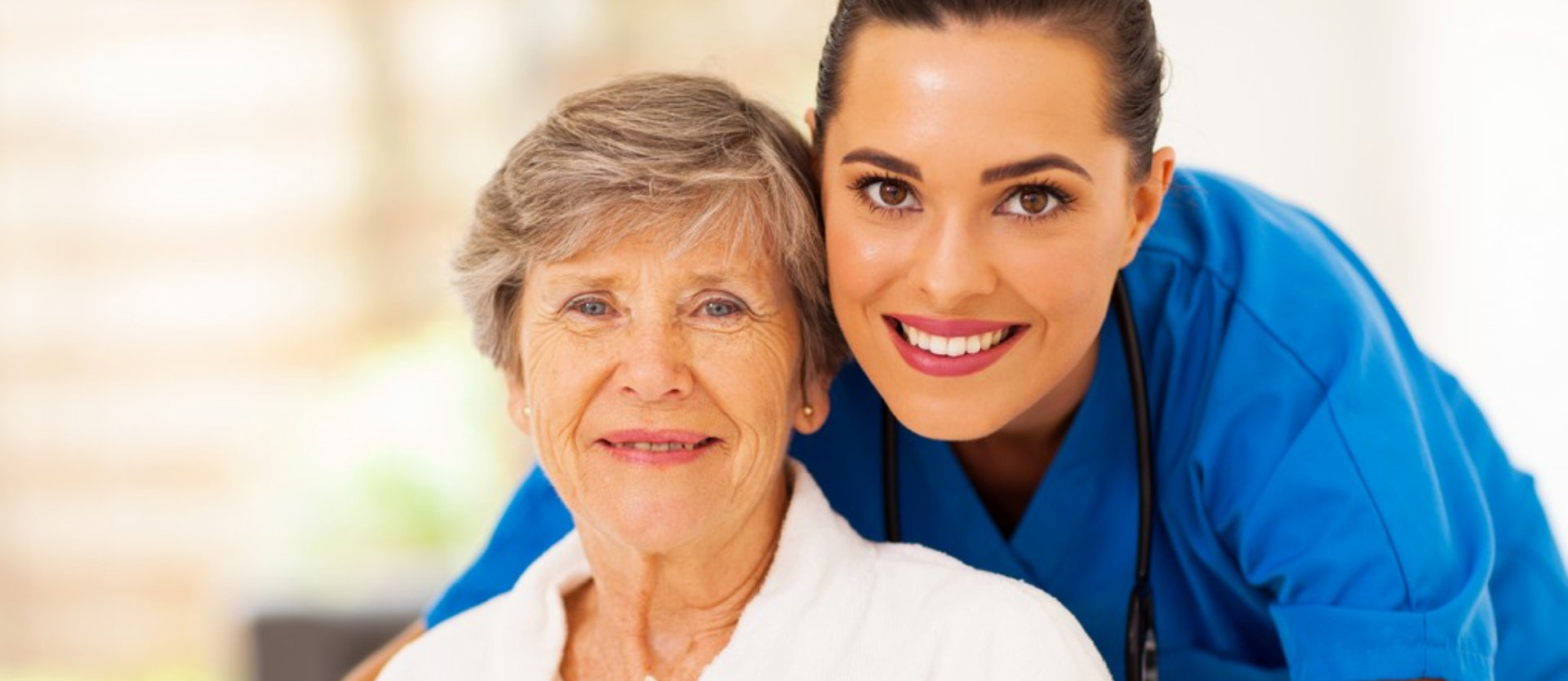 female nurse and senior woman smiling
