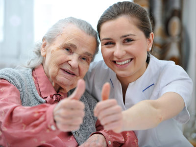 senior woman and female nurse are showing thumbs up